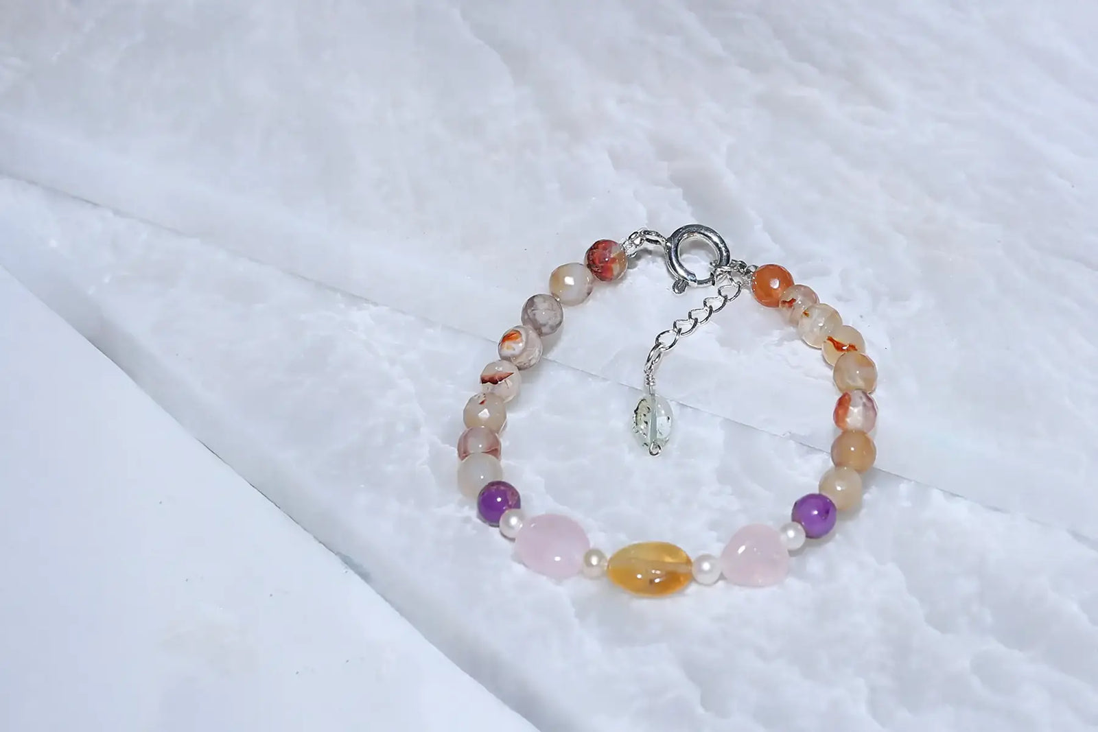 Multicolored beaded bracelet on a white fabric background
