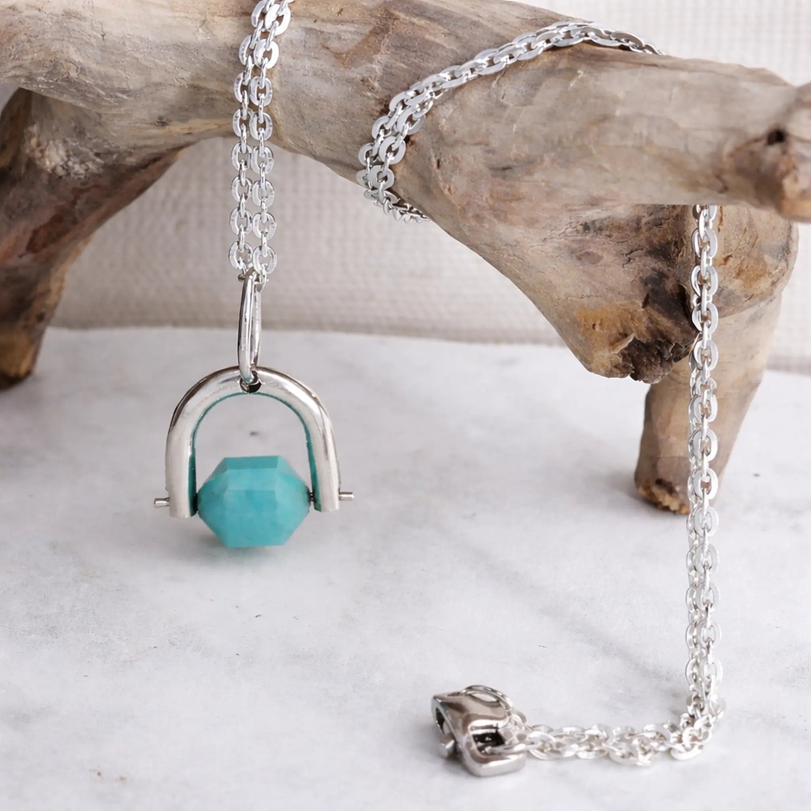 Silver necklace with amazonite pendant on a wooden surface