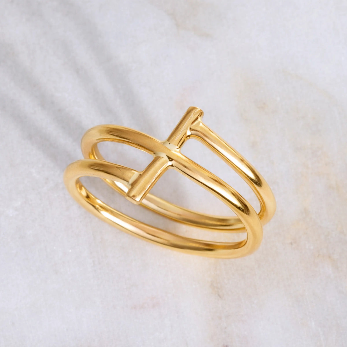 Handmde 14K gold ring with a unique design on a light marble background