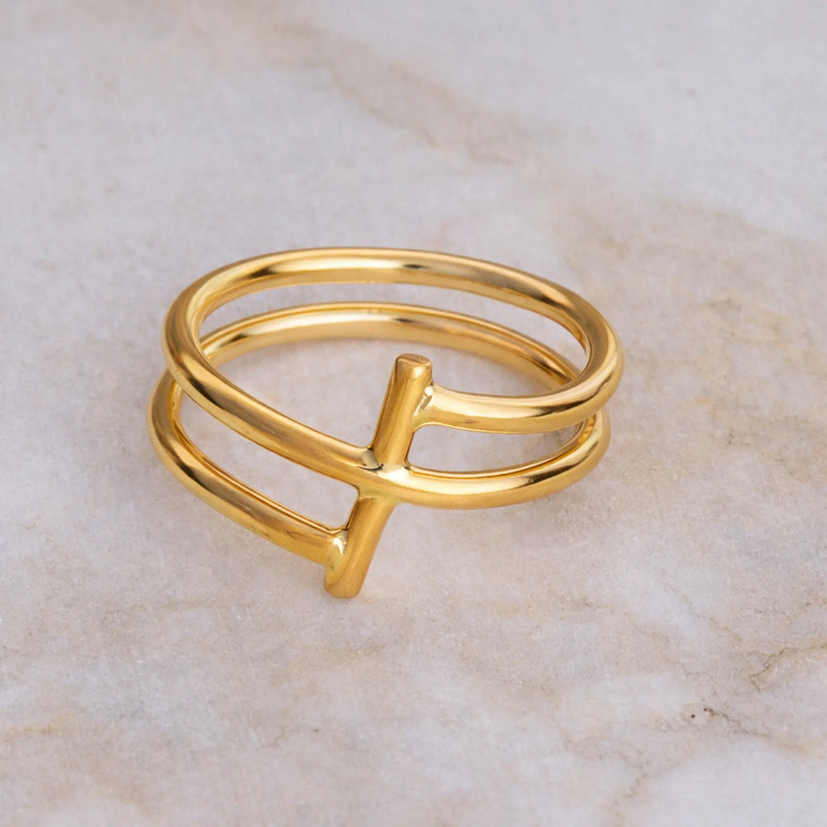 Gold ring with a unique design on a marble surface